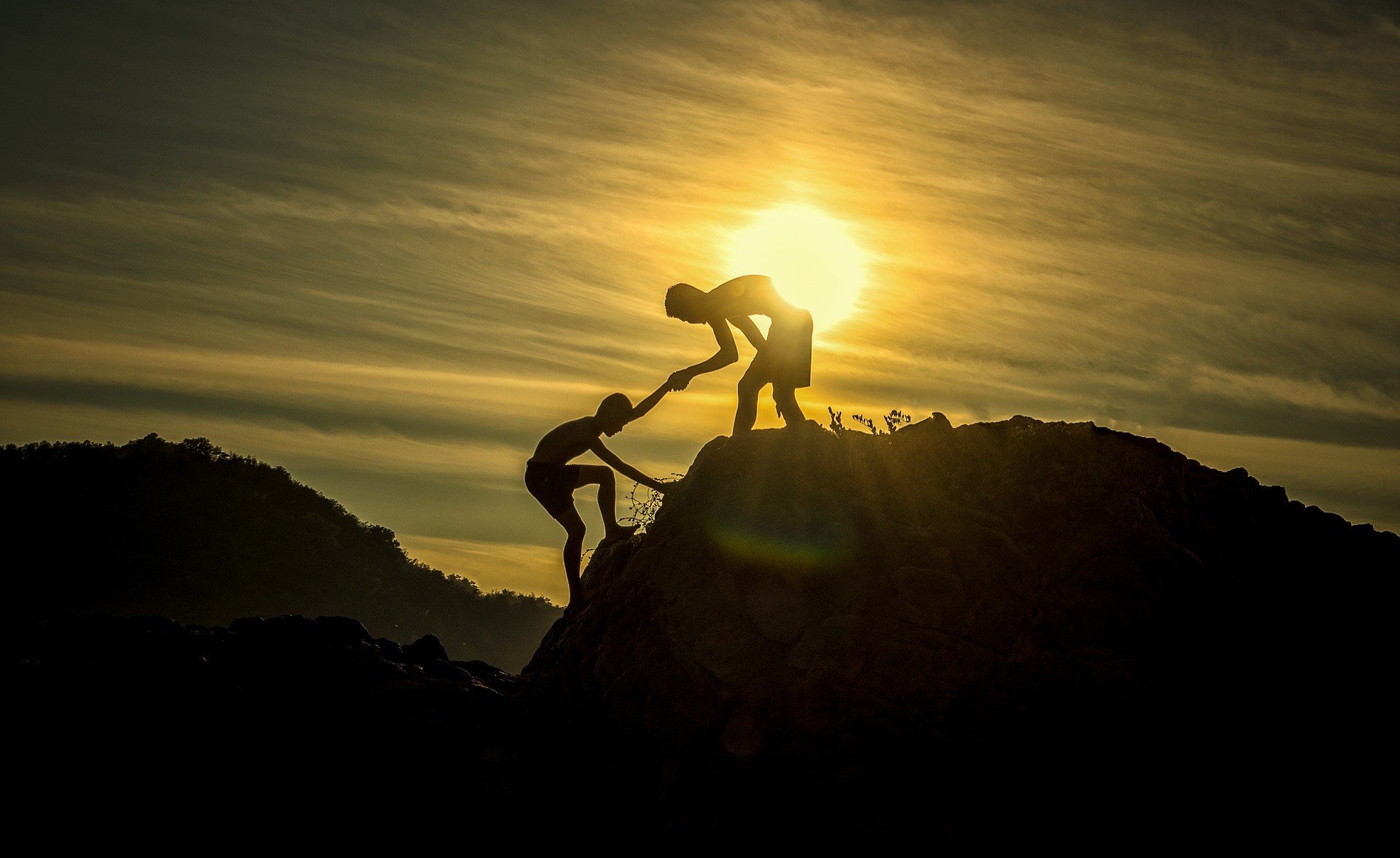 Silhouette of a person helping another to the top of a mountain at sunset.

Access resources to help you tackle life's little surprises.